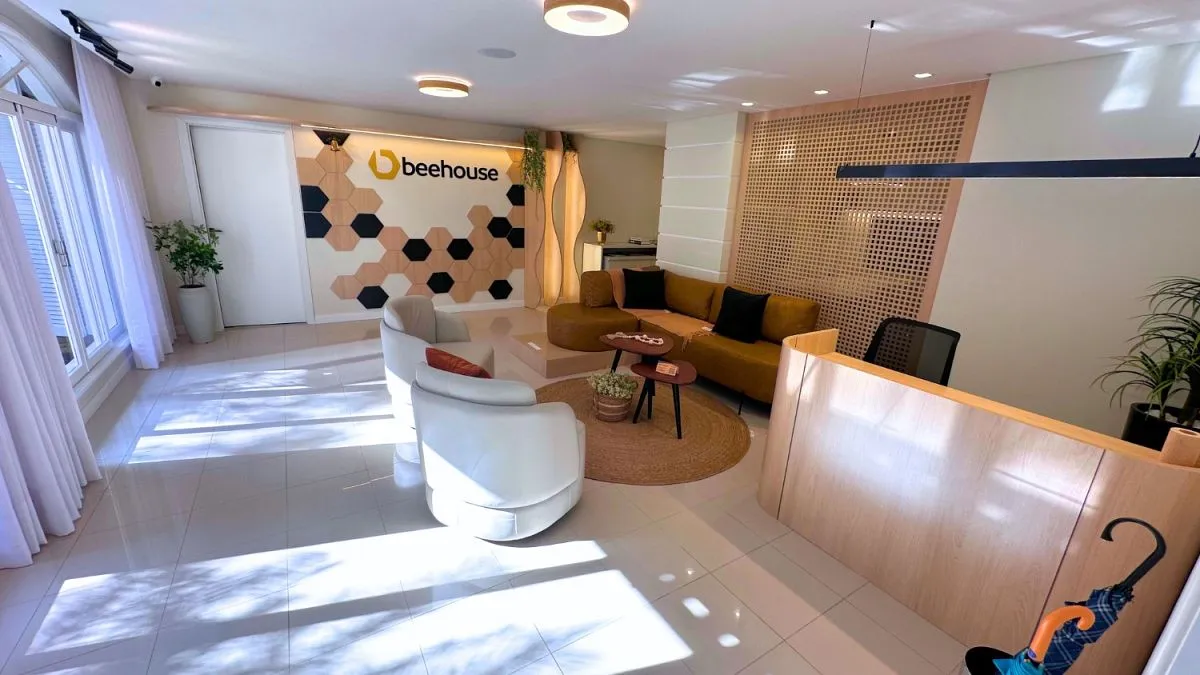 Recepção da Beehouse, com balcão de atendimento e a marca na parede.